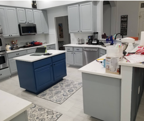 Kitchen renovation featuring blue island with white cabinets